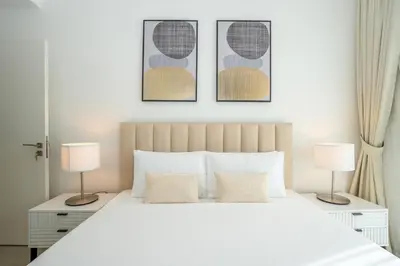 a bedroom with a white bed with two lamps at Homesgetaway Luxury 2BR at Socio Dubai hills in Dubai