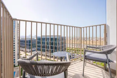 a balcony with two chairs and a table at Homesgetaway Luxury 2BR at Socio Dubai hills in Dubai