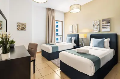 a hotel room with two beds and a desk at Spacious, Deluxe, 5BR plus maidroom on JBR walk Next to Beach ,Tram & Mall by La Buena Vida Holiday Homes in Dubai