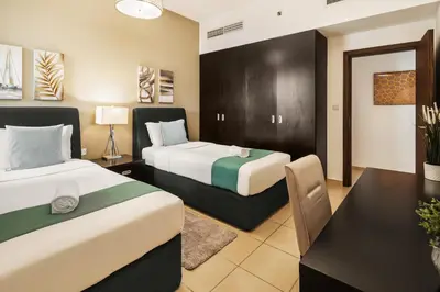 a hotel room with two beds and a desk at Spacious, Deluxe, 5BR plus maidroom on JBR walk Next to Beach ,Tram & Mall by La Buena Vida Holiday Homes in Dubai
