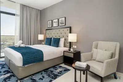a bedroom with a king sized bed and a chair at Gorgeous Studio Apartment in DAMAC Celestia B Dubai South by Deluxe Holiday Homes in Dubai