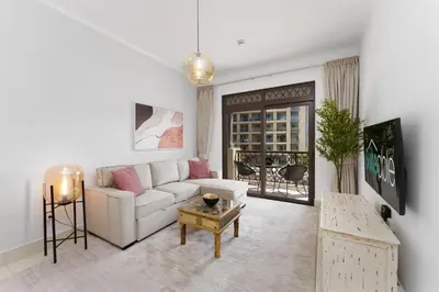 a living room with a white couch and a table at Green living chic 1 bedroom apartment in Dubai