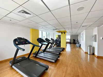 a row of treadmills in a gym with wooden floors at Silkhaus Studio at Dubai Marina Near Marina Mall in Dubai