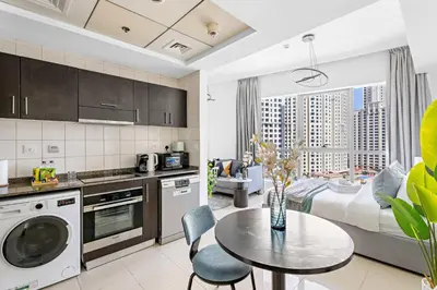 a kitchen with a table and a living room at Silkhaus Studio at Dubai Marina Near Marina Mall in Dubai