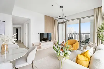 a living room with a white couch and a tv at Silkhaus Elite 2BDR with View with Pool & Gym in Dubai