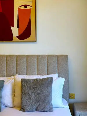 a bedroom with a bed with a painting on the wall at WOW Studio w/ Balcony and Canal View in Marina in Dubai