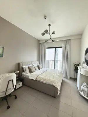 a bedroom with a bed and a chair and a window at 3 bedrooms + maids room, Full Park view in Dubai