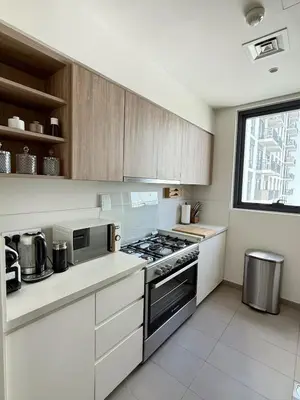 a kitchen with white cabinets and a stove top oven at 3 bedrooms + maids room, Full Park view in Dubai