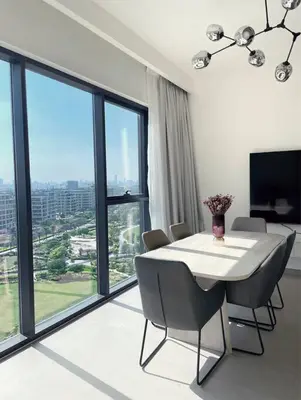 a dining room with a table and chairs and a large window at 3 bedrooms + maids room, Full Park view in Dubai