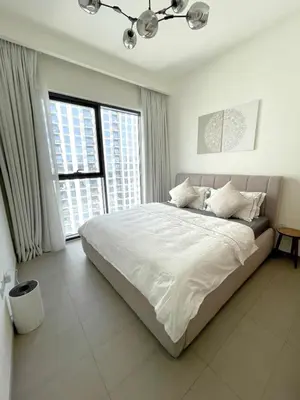a bedroom with a bed with white sheets and windows at 3 bedrooms + maids room, Full Park view in Dubai