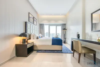 a bedroom with a bed and a desk and a desk at Overlooking Canal Views, Fam-Friendly 2BR Unit, Damac Majestine Tower, Business Bay by Deluxe Holiday Homes in Dubai