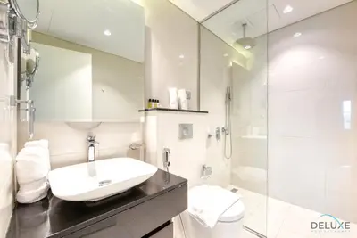a bathroom with a sink and a toilet and a shower at Overlooking Canal Views, Fam-Friendly 2BR Unit, Damac Majestine Tower, Business Bay by Deluxe Holiday Homes in Dubai
