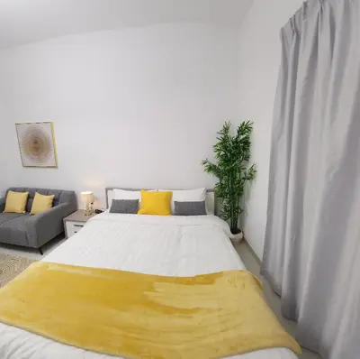 a bedroom with a large bed with a yellow blanket at Elite 6 Residence - Sports City by Golden Casa in Dubai
