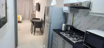 a kitchen with a refrigerator and a table with chairs at Elite 6 Residence - Sports City by Golden Casa in Dubai