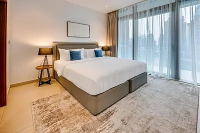 a bedroom with a large bed and a large window at Panoramic canal views from brand new 3BD apartment in Dubai