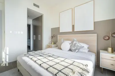 a bedroom with a large white bed with two mirrors at GuestReady - Glamourous home in Downtown Dubai in Dubai
