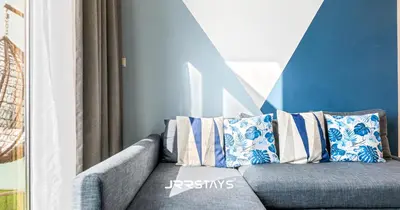a couch with pillows sitting in a room at Upgraded 1BR Apartment in Bloom Tower B - JVC in Dubai