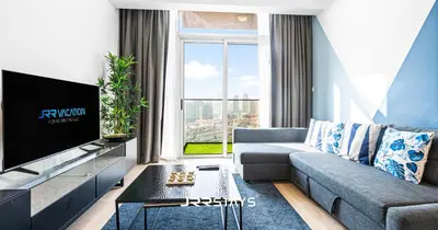 a living room with a couch and a tv at Upgraded 1BR Apartment in Bloom Tower B - JVC in Dubai