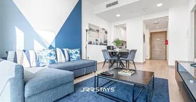 a living room with a couch and a table at Upgraded 1BR Apartment in Bloom Tower B - JVC in Dubai