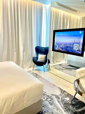 a bedroom with a bed and a chair and a television at Best View Security System Burj Kalifa View in Dubai