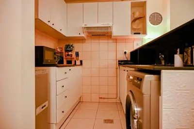a small kitchen with white cabinets and a dishwasher at Downtown Dubai Mall walk & Burj Khalifa DIFC 5 mins in Dubai