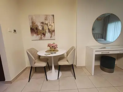 a small white table with two chairs and a mirror at Downtown Dubai Mall walk & Burj Khalifa DIFC 5 mins in Dubai