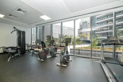 a gym with treadmills and elliptical machines and windows at Beautiful 2BR at Silverene Towers A Dubai Marina by Deluxe Holiday Homes in Dubai