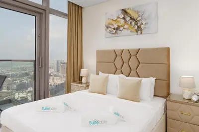 a bedroom with two beds and a large window at Experience Opulent Living at Paramount Midtown in Dubai
