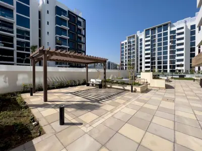 a pavilion in a courtyard with tall buildings at Frank Porter - Riviera 26 in Dubai