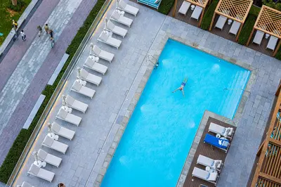 an overhead view of a pool with a person in the water at SmartStay at Address Opera - Unique Burj Khalifa Views - Brand New Luxury Residences in Dubai