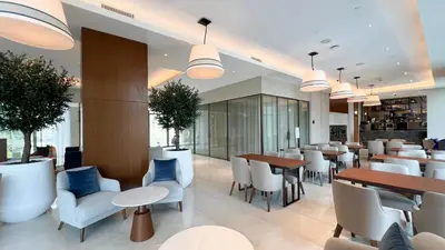 a restaurant with white chairs and tables and blue chairs at SmartStay at Address Opera - Unique Burj Khalifa Views - Brand New Luxury Residences in Dubai