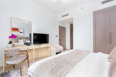 a bedroom with a bed and a desk with a television at Mystic - Act One Tower in Dubai