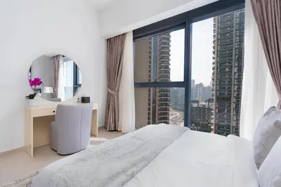a bedroom with a white bed and a large window at Mystic - Act One Tower in Dubai