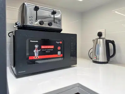a microwave oven on a counter next to a kettle at Mystic - Forte Tower 2 in Dubai