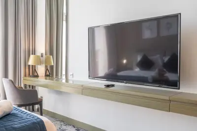 a large flat screen tv on a wall in a hotel room at Mystic - Damac Maison Prive Tower B in Dubai