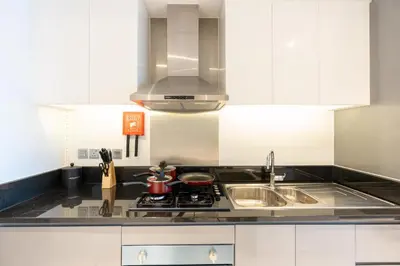 a kitchen with a sink and a stove top oven at Mystic - Damac Maison Prive Tower A in Dubai
