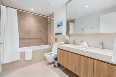 a bathroom with a toilet and a tub and a sink at Burj Khalifa & Dubai Dancing Fountain View, 54th Floor & Dubai Mall Access in Dubai