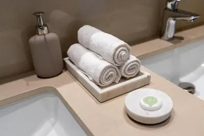 a bathroom counter with towels and a bottle of soap at Burj Khalifa & Dubai Dancing Fountain View, 54th Floor & Dubai Mall Access in Dubai