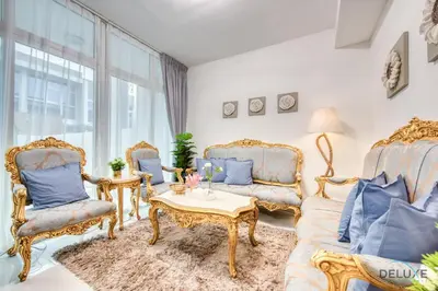 a living room with two chairs and a table at Tranquil 3BR Townhouse at Albizia Damac Hills 2 by Deluxe Holiday Homes in Dubai