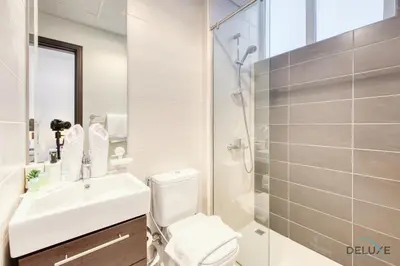 a bathroom with a toilet and a sink and a shower at Tranquil 3BR Townhouse at Albizia Damac Hills 2 by Deluxe Holiday Homes in Dubai