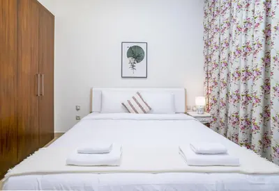 a bedroom with a large white bed and curtains at Vacay Lettings - Stunning Burj Khalifa fountain view near Dubai mall in Dubai