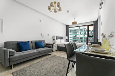a living room with a couch and a table with blue pillows at StoneTree - Modern Studio - Special Offer! in Dubai