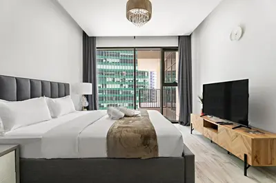 a bedroom with a large bed and a flat screen tv at StoneTree - Modern Studio - Special Offer! in Dubai