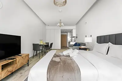 a large bedroom with a large bed and a tv at StoneTree - Modern Studio - Special Offer! in Dubai