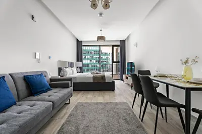 a living room with a couch and a bed and a table at StoneTree - Modern Studio - Special Offer! in Dubai