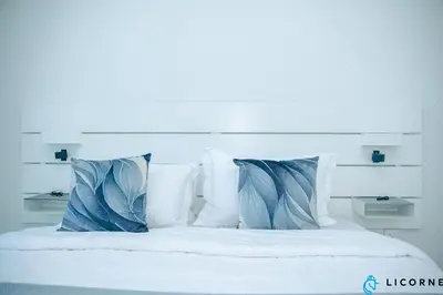a bed with white pillows and blue pillows at Unveil Downtown Luxury, 1BR Majestic Skyline Views - Downtown Views ll in Dubai