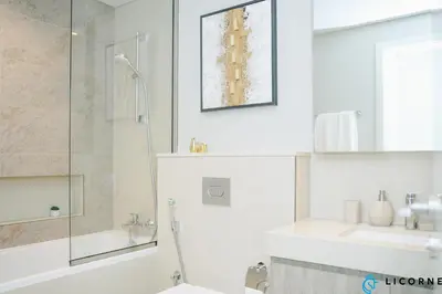 a white bathroom with a shower and a sink at Unveil Downtown Luxury, 1BR Majestic Skyline Views - Downtown Views ll in Dubai