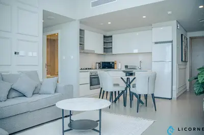a living room and kitchen with a couch and a table at Unveil Downtown Luxury, 1BR Majestic Skyline Views - Downtown Views ll in Dubai