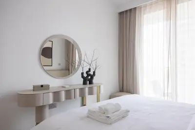 a white bedroom with a mirror and a bed at Beachfront Elegant 2BD Condo with Breathtaking Views -15AB01 in Dubai