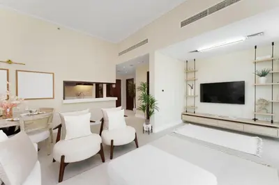 a living room with white furniture and a flat screen tv at Maison Privee - Modern Beach Living in the Heart of Dubai Marina in Dubai